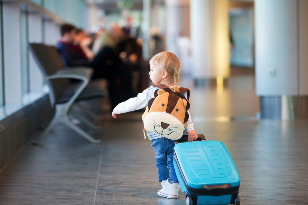 Toddler travelling with a suitcase